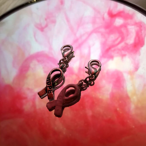 en berlock med temat rosa bandet