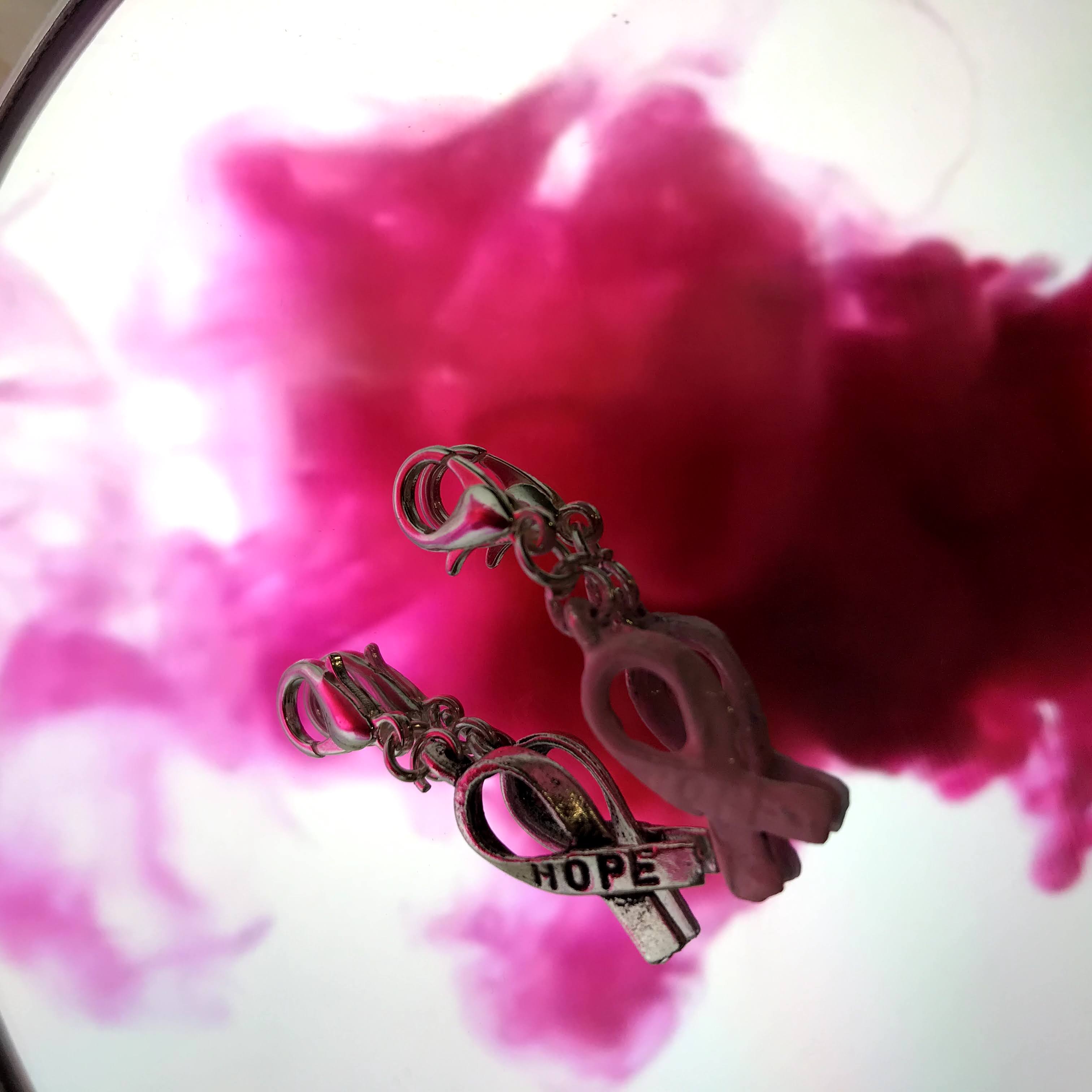 en berlock med temat rosa bandet